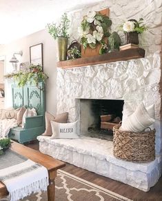 a living room filled with furniture and a fire place covered in plants on top of a mantle