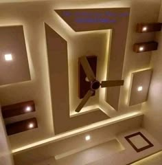 a ceiling with lights and a fan in the center is lit up by recessed lighting