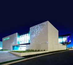 the exterior of a building lit up at night with stars on it's side