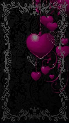 purple hearts hanging from strings on a black background