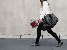 a woman walking down the street with her purse