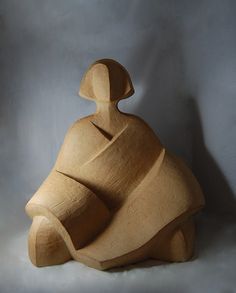 a wooden sculpture sitting on top of a white surface