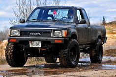 a black truck parked on top of a dirt field