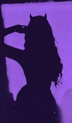 the silhouette of a woman with long hair is shown in front of a purple background