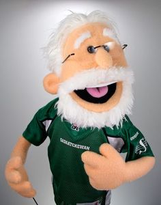 the mascot is wearing a green jersey and white beard, with his hands in his pockets