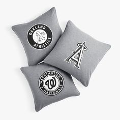 three pillows with logos on them sitting next to each other in front of a white background