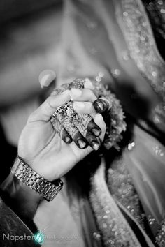 black and white photograph of a woman's hands holding an ornate piece of jewelry