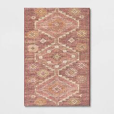 an orange and pink rug on a white wall