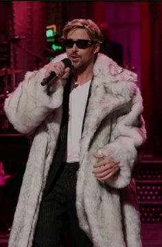 a man in a fur coat singing into a microphone