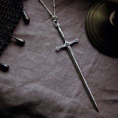 a cross with a chain attached to it sitting on a table next to other items