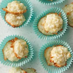 several cupcakes with white frosting in blue paper cups