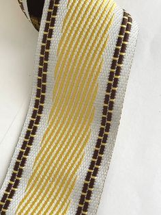 a yellow and brown striped tie laying on top of a white table