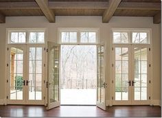 an empty room with french doors and wood floors