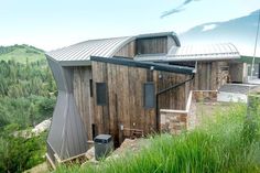 a small wooden building sitting on top of a lush green hillside