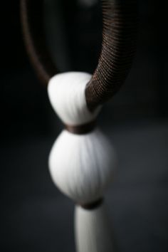 an elephant's trunk sticking out of the top of two white balls in front of a black background