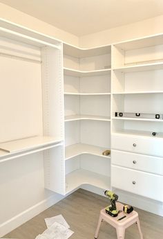 an empty white closet with shelves, drawers and other items on the floor in front of it