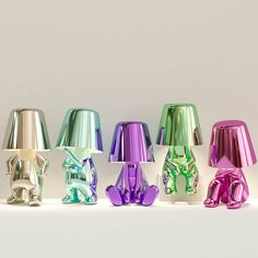 an assortment of colorful lamps sitting on top of each other