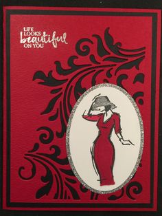 a red and black card with an image of a woman in a dress on it