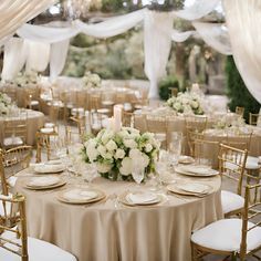 the tables are set with white flowers and place settings