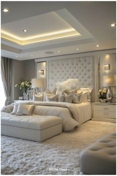 a large white bed sitting in the middle of a bedroom