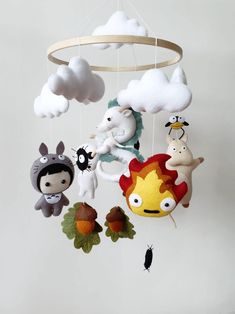 a mobile with various stuffed animals hanging from it's sides and clouds in the background