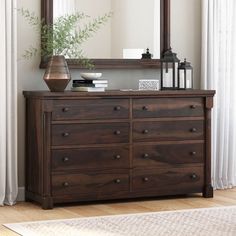 a wooden dresser sitting in front of a mirror