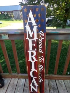 a wooden sign that says america on it sitting on a deck in front of some grass