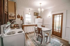 a kitchen with white walls and wooden floors