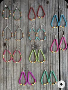 several pairs of earrings are displayed on a wooden surface