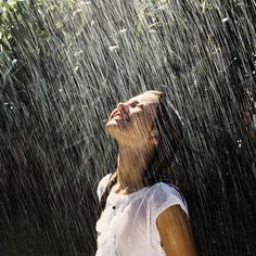 a woman standing in the rain with her eyes closed