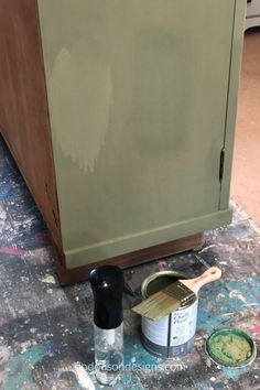 the paint is being applied on the floor next to an old cabinet and buckets