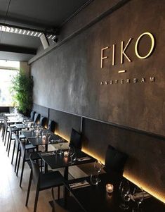 an empty restaurant with tables and chairs in front of the wall that says fiko