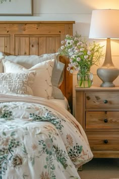 a bed with white and green comforter next to a night stand