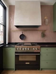 a stove top oven sitting inside of a kitchen next to a wall mounted range hood