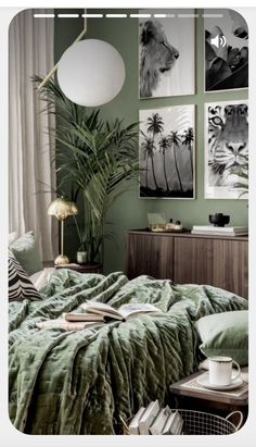 a bedroom with green walls and pictures on the wall above the bed, along with a coffee table