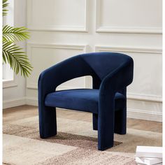 a blue chair sitting on top of a carpeted floor next to a potted plant