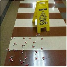 a caution sign sitting on top of a floor next to candy candies in front of it