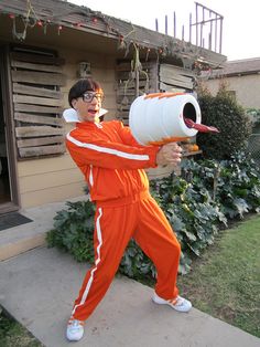 a man in an orange jumpsuit is holding a white barrel