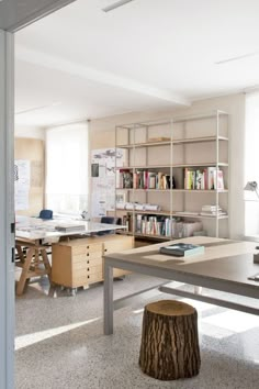 an office with desks, bookshelves and chairs