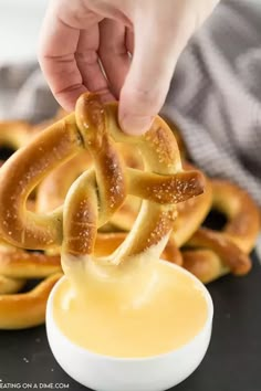 pretzel rings being dipped with mustard sauce