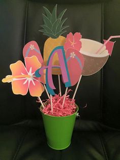 a cup filled with cake pops sitting on top of a green potted plant in front of a black chair