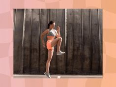 a woman in an orange sports bra and neon shorts is standing with her legs crossed