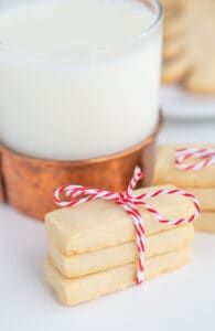 cookies tied with red and white twine next to a glass of milk