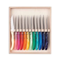 a wooden box filled with lots of different colored knives