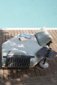 a bed sitting on top of a wooden floor next to a swimming pool