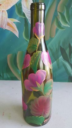 a vase with flowers painted on it sitting in front of a wallpapered background