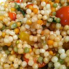 corn salad with tomatoes and peas in a white bowl