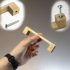 a hand holding a wooden block with nails and screws attached to it next to other woodworking tools