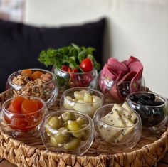 an assortment of different types of food in small bowls on a wicker platter