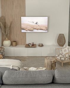 a living room filled with furniture and a flat screen tv mounted to the side of a wall